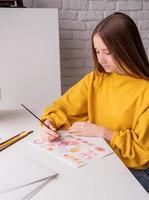 artiste féminine peignant une image à l'aquarelle en studio photo