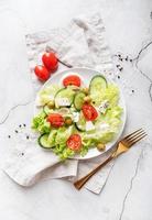 salade grecque avec fromage feta, légumes frais et olives sur fond rustique blanc vue de dessus