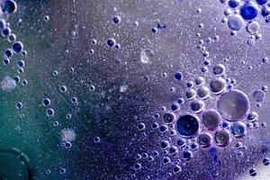 abstrait ou texture avec des bulles d'huile sur la surface de l'eau violette photo