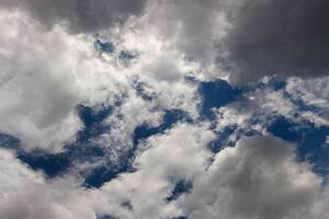 couvert ciel, plein cadre gris des nuages avec lacunes de bleu ciel photo