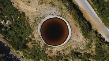 Haut vue de gouffre. agrafe. incroyable Naturel phénomène dans forme de gouffre avec marron l'eau dans champ. karst gouffre avec l'eau près Autoroute dans champ photo