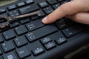 Gros plan sur le bouton poussoir de l'index féminin entrer sur le clavier de l'ordinateur photo