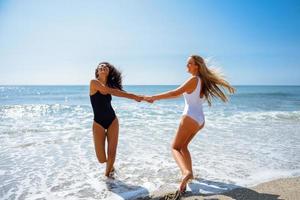 deux femmes en maillot de bain s'amusant sur la plage photo