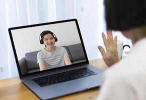 femme asiatique âgée utilisant un ordinateur pour passer un appel vidéo et parler avec sa fille à la maison photo