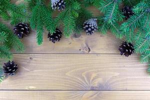 branches d'arbre de Noël avec des décorations rouges sur un fond de mur en bois. modèle pour carte de voeux ou design. photo