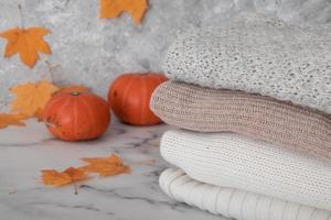 nature morte d'automne avec des chandails tricotés, des feuilles mortes, des citrouilles. photo