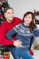 couple d'âge moyen dans la chambre avec arbre de noël et cheminée décorée, famille aimante photo