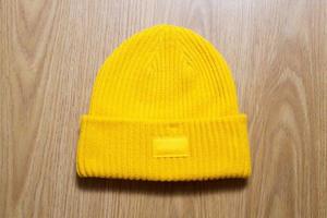 chapeau d'hiver jaune sur fond en bois, bonnet d'hiver mock up photo