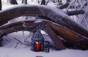 une petit bougie est séance sur une Journal dans le neige photo