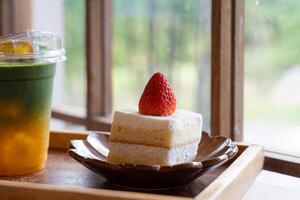 fraise court gâteau servi avec Orange matcha vert thé dans restaurant photo