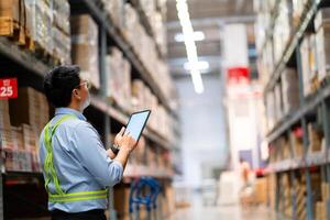 entrepôt ouvrier dans Sécurité uniforme avec tablette ordinateur à la recherche à marchandise dans grand entrepôt logistique et exportation affaires logistique Distribution centre. photo