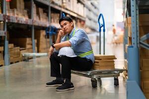 asiatique entrepôt ouvrier qui est malheureux après étant mis à la porte de le sien emploi sans emploi gens échouer, désespoir, dépression. ouvriers sont fatigué de travail. photo