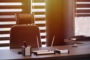 lieu de travail de bureau d'affaires. la lumière du soleil sur le lieu de travail pour le chef, le patron ou d'autres employés. table et chaise confortable. lumière à travers les stores à demi ouverts photo