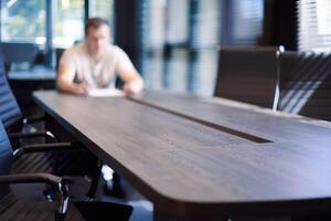 employé dans la salle de conférence du bureau. gestionnaire à table dans une salle de réunion moderne pour les négociations commerciales et les réunions d'affaires. entretien avec un nouvel employé. photo