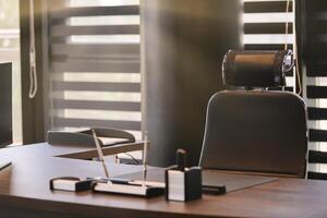 lieu de travail de bureau d'affaires. la lumière du soleil sur le lieu de travail pour le chef, le patron ou d'autres employés. table et chaise confortable. lumière à travers les stores à demi ouverts photo