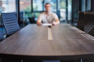 employé dans la salle de conférence du bureau. gestionnaire à table dans une salle de réunion moderne pour les négociations commerciales et les réunions d'affaires. entretien avec un nouvel employé. photo