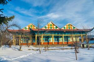 le salopette mosquée, une vibrant en bois structure dans karakol, expositions distinctif chinois musulman savoir-faire, avec coloré géométrique motifs orner ses façade, islamique, minaret, neige, brillant ciel. photo