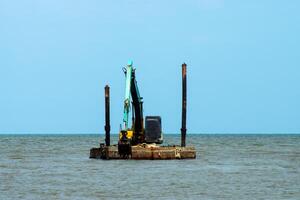 Machines sont dragage le sable dans le mer. photo