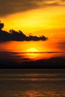 le coucher du soleil à le Lac avec foncé nuage. photo