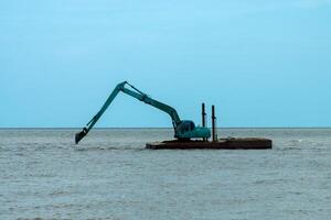 Machines sont dragage le sable dans le mer. photo