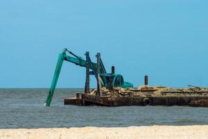 Machines sont dragage le sable dans le mer. photo
