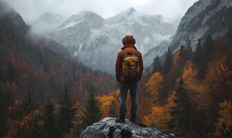 ai généré Montagne ascension - retour vue de Montagne grimpeur portant chapeau et sac à dos, permanent sur une osciller, regarder à le majestueux montagnes devant photo