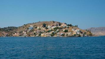 belle vue depuis l'eau de l'île colorée de symi en été. Grèce photo