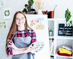 jeune femme artiste tenant une palette de couleurs travaillant dans son studio photo