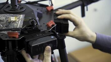 proche en haut pour mains en mettant batterie dans le quadricoptère, tournage préparation. agrafe. drone installation, insertion accumulateur dans le machine. photo