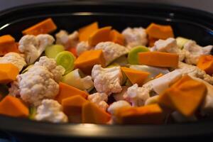 brut des légumes Couper dans petit pièces préparé pour fumant, chou-fleur, butternut, poireau, carotte photo