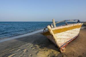 vieux coloré en bois bateau à le plage avec bleu mer photo