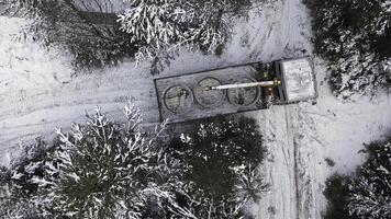 aérien Haut vue de une grue un camion en essayant à tour autour sur étroit hiver route. agrafe. véhicule et et hiver neige couvert des arbres. photo