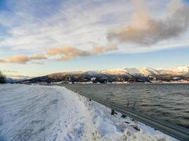conduire au lever du soleil à travers les montagnes et les fjords en norvège. photo