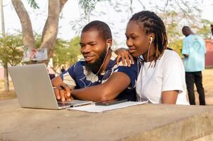 souriant des couples Extérieur en utilisant leur portable pour achats en ligne photo