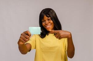 femme détient une Vide affaires carte en dehors dans de face de sa souriant affronter. photo