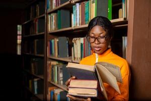 magnifique fille dans une bibliothèque. Dame en train de lire livre dans le bibliothèque. photo