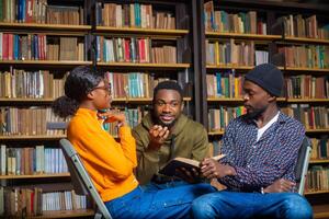 gens dans le bibliothèque discuter à propos leur examen photo