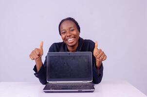 portrait de un excité magnifique Jeune noir femme montrer du doigt à sa portable écran photo