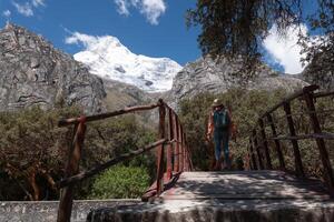 touristique des croix une en bois pont à atteindre le llanganuco lagune dans Pérou. photo