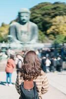 femme touristique visite dans Kamakura, Kanagawa, Japon. content voyageur tourisme le génial Bouddha statue. point de repère et populaire pour touristes attraction près Tokyo. Voyage et vacances concept photo