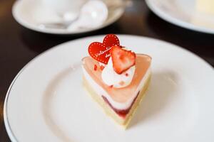 fait maison fromage gâteau avec Frais des fraises et chaud thé Coupe. dessert et boisson pour content Valentin journée fête photo