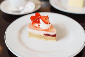 fait maison fromage gâteau avec Frais des fraises et chaud thé Coupe. dessert et boisson pour content Valentin journée fête photo