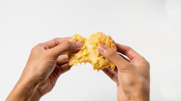 deux mains sont scission une vanille éclair isolé sur une blanc Contexte photo