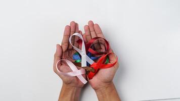 homme en portant coloré rubans dans le sien mains. soutien monde cancer journée photo