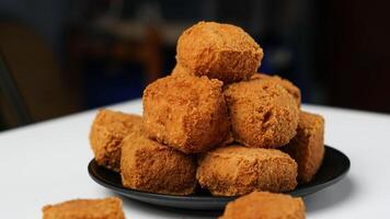 frit Tofu sur une noir assiette dans une blanc Contexte photo