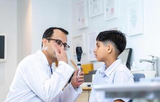 enfant indien choisissant des lunettes dans un magasin d'optique, garçon faisant un examen de contrôle des yeux avec un optométriste dans un magasin d'optique, optométriste faisant des tests de vue pour un enfant patient dans une clinique photo