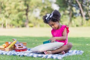 mignonne peu fille en jouant avec jouet dans le jardin, enfant fille en jouant avec Kalimba Extérieur photo