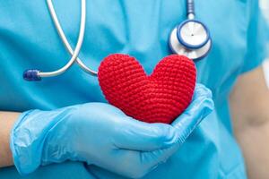 médecin tenant un coeur rouge dans la salle d'hôpital, concept médical solide et sain. photo