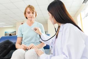 une femme médecin utilise un stéthoscope pour vérifier une vieille patiente à l'hôpital. photo