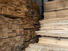 stockage de planches de bois sous un auvent avec de la neige et de la glace fondue sur le sol photo